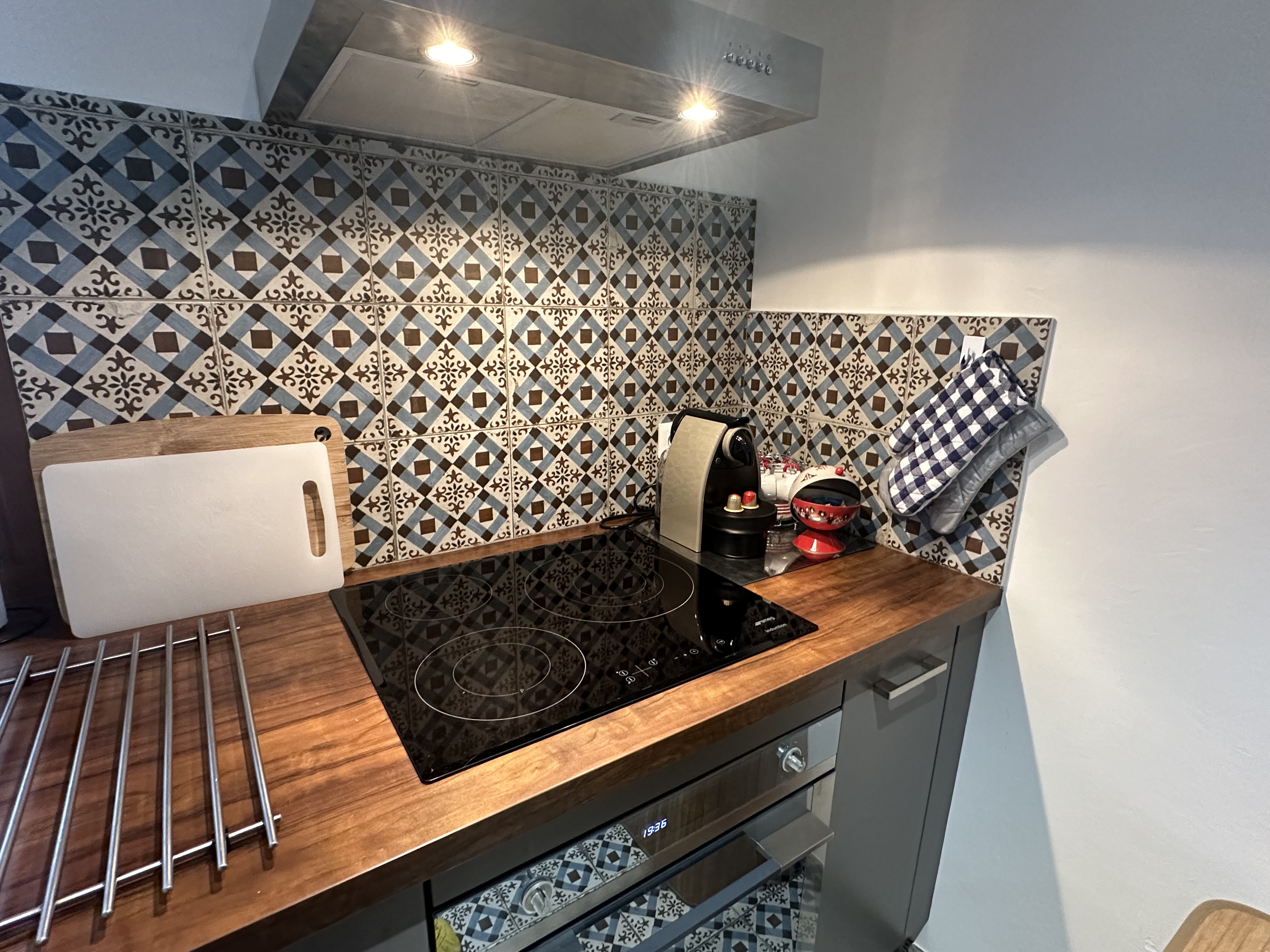 Plan de travail cuisine avec plaque à induction et crédence en carreaux de ciment